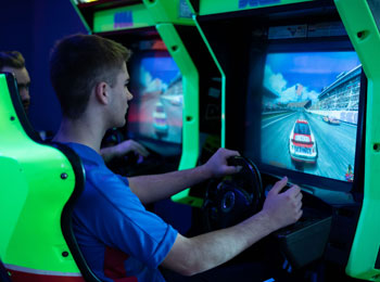 Young man racing in an arcade game.