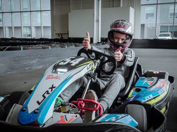 Young boy in a kart on a karting track.