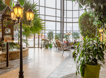 Entrance to the indoor garden and people seated next to the panoramic window.