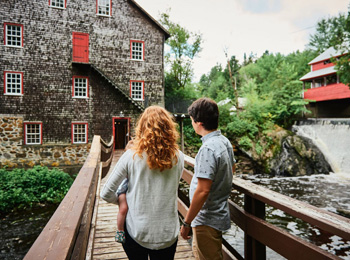 Young family on the bridge in front of the wool mill.