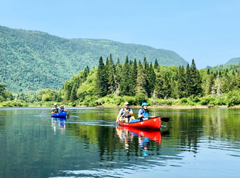 Two couples in two canoes on the lake.