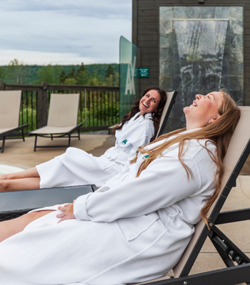 Two women on patio chairs at the spa facilities at Ax Hotel.