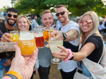 Group of smiling people clinking their glasses of beer.