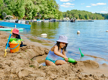 Little girl building a sand castle on the beach.