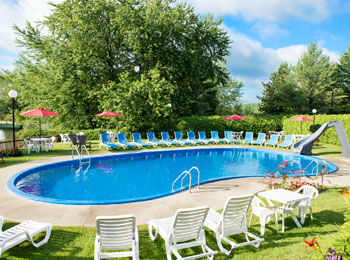 Outdoor in-ground pool surrounded by sun loungers.