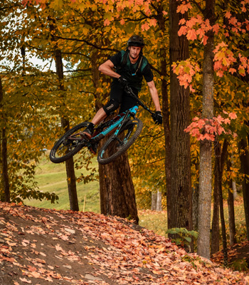 Mountain biker making a jump in a fall setting.