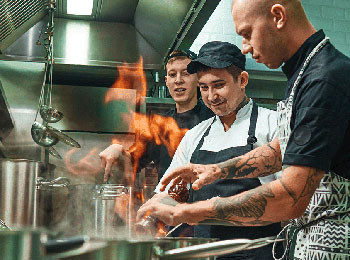 Three men working in an industrial kitchen.