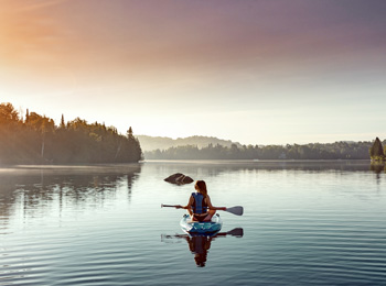 Woman on the lake on a paddleboard at Estérel Resort.