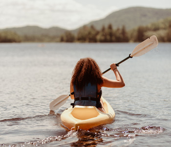 Jeune femme en kayak sur le lac. Young woman in a kayak on the lake.