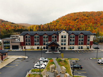 Front view of the Microtel Inn in Tremblant with a background of fall foliage.