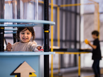 Little girl enjoying the tinkering challenges at the Bombardier Museum of Ingenuity.