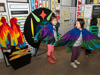 3 kids in costumes visiting the museum exhibit