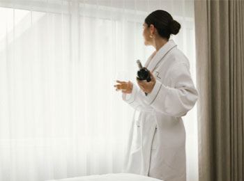 Woman wearing a bathrobe in a hotel room.