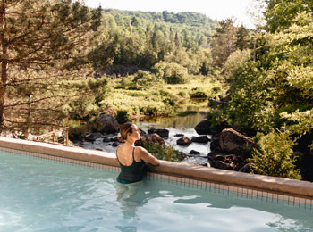 Woman contemplating nature in a thermal pool.