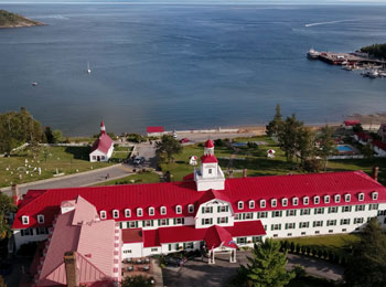 Aerial view of a red-roofed waterfront hotel.