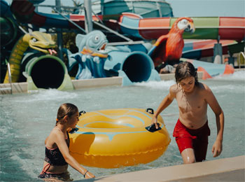 Young girl and boy with an inflatable tube in a pool.