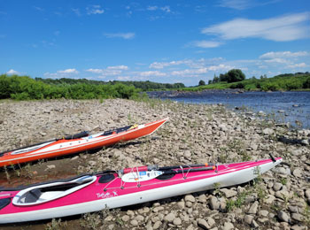 Two kayaks on the banks of a stream.