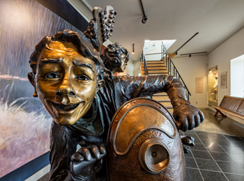 Close-up of a bronze work depicting a smiling person.