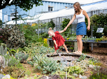 Mother and young daughter in front of a garden of cactuses.