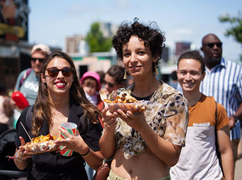 Two festival-goers with street food in hand.